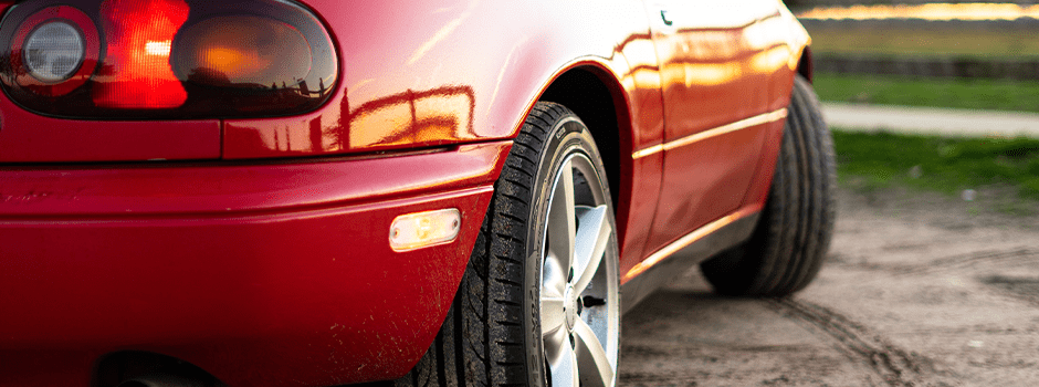 Red car showing side view including wheels